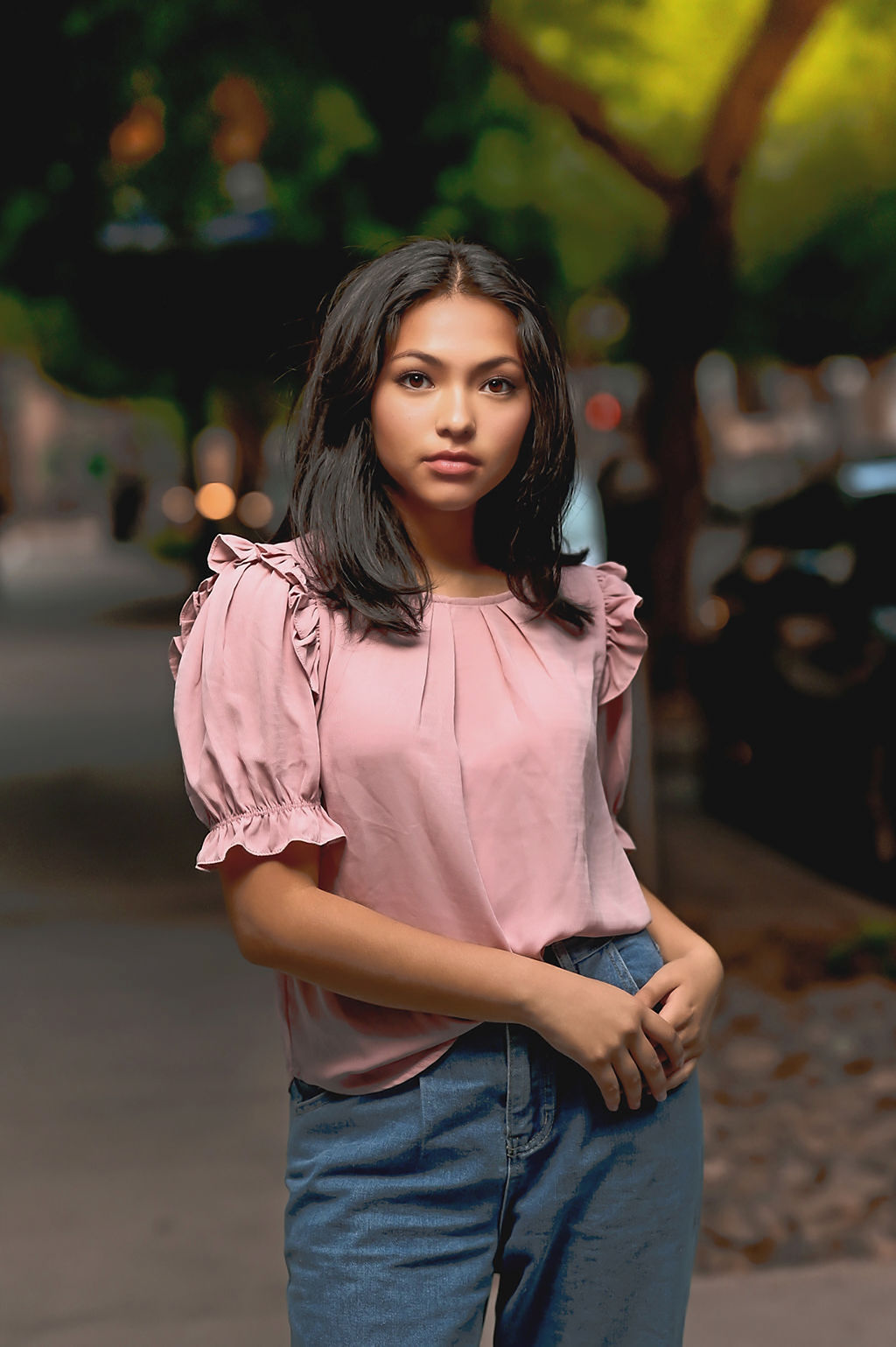 A woman in a pink shirt and jeans walks on a sidewalk on the street after visiting boutiques in des moines