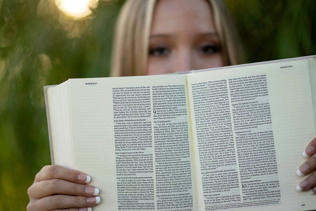 Details of a bible being held up by a blonde high school senior after finding tutors in des moines