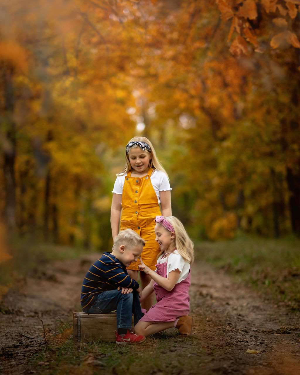 Three toddler siblings play in a park trail in fall after visiting Janes Family Shop