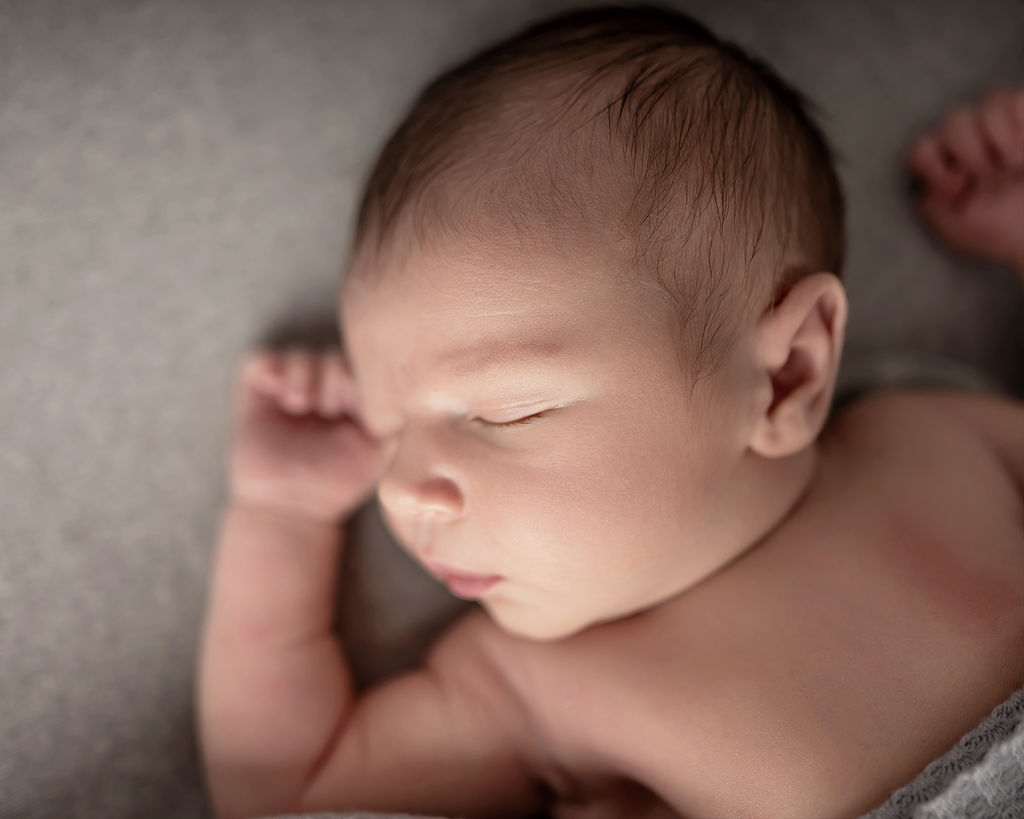 A newborn baby sleeps on its back after visiting Little Wonders Wellness