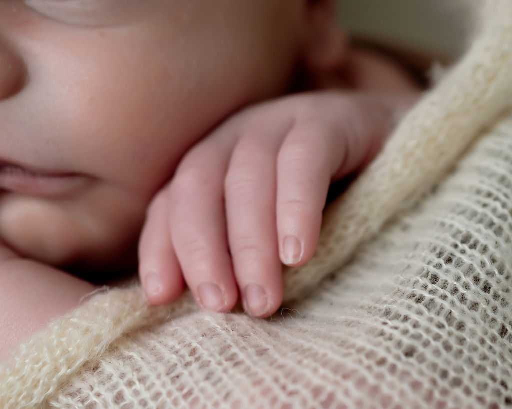 Details of a newborn baby's hand on a blanket thanks to Heart Of Iowa Midwifery